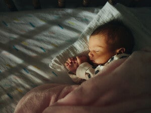 Bebé pequeño durmiendo en su cuna. Sueño infantil.