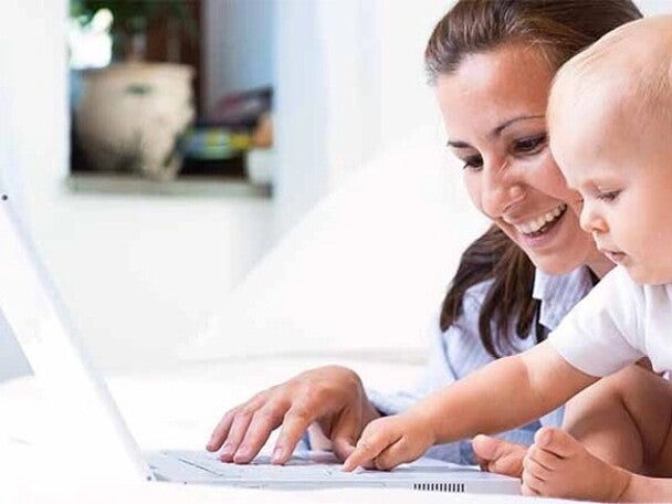 madre trabajando con su hijo en brazos