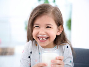 Niña sonriente tomando un vaso con leche Niña sonriente tomando un vaso con leche