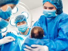 Doctores cargando bebé prematuro luego del parto Doctores cargando bebé prematuro luego del parto
