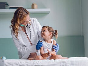 Conoce qué es la escarlatina Doctora revisando al bebé con escarlatina