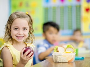 Prevenir la obesidad infantil Niña comiendo frutas en la escuela