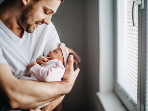 Los granitos en la cara de los bebés es un fenómeno común Papá alzando su bebé y revisando los granito de su cara