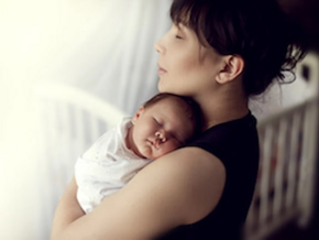 Cuidados para evitar complicaciones del puerperio Mamá abrazando a bebé durmiendo en el periodo del puerperio.