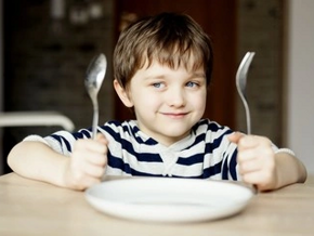 Niño alegre con sus cubiertos esperando comer alimentos constructores Niño alegre con sus cubiertos esperando comer alimentos constructores