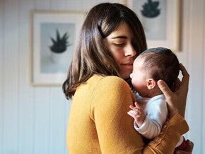 Mamá cargando a un bebé recién nacido.