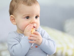 Bebé comiendo con las manos.