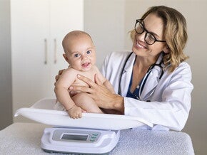 Doctora pesando al bebé.