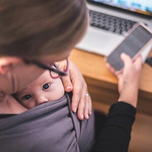 Como lidiar con la culpa parental madre trabajando con su hijo en brazos