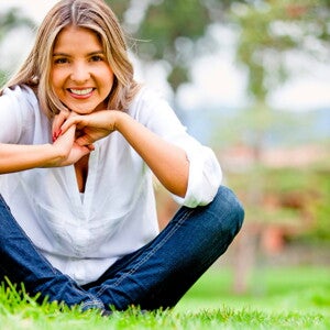Mamá sentada en el pasto sonriendo