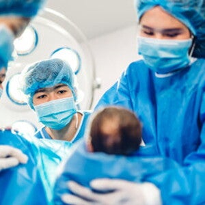 Doctores cargando bebé prematuro luego del parto Doctores cargando bebé prematuro luego del parto