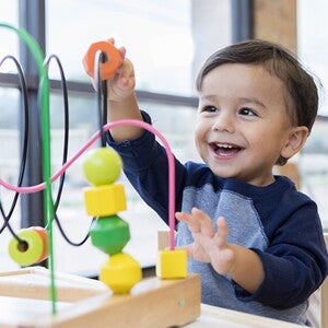 Como fomentar la independencia en bebés Niño feliz jugando jugando con juguete interactivo