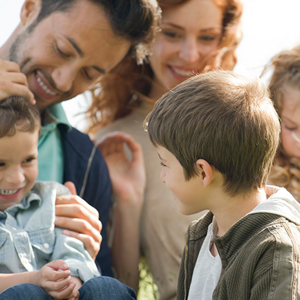 Beneficios y desafíos de las familias ensambladas Una linda familia disfrutando juntos en el césped con un niño