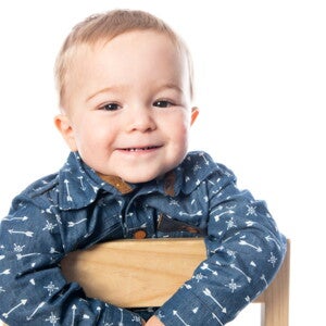Bebé sonriendo mientras está sentado sobre una silla Bebé sonriendo mientras está sentado sobre una silla
