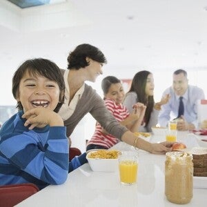 Familia el desayuno juntos en la cocina, sentados alrededor de la mesa.