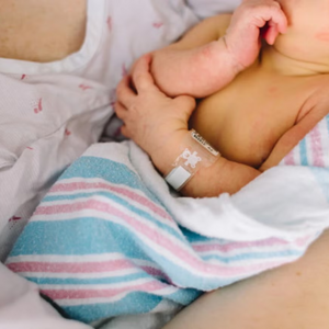 Mamá sosteniendo a un bebé recién nacido con ictericia neonatal.