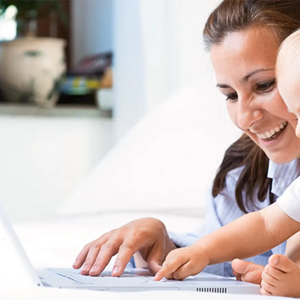Mamá y bebé sonreindo en frente de un ordenador portátil