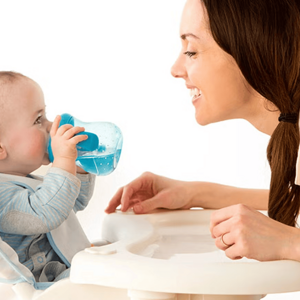 Cuándo dar agua al bebé Mujer adulta y bebé tomando agua en un vaso entrenador
