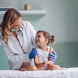 Conoce qué es la escarlatina Doctora revisando al bebé con escarlatina