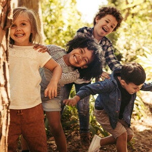 Conoce la importancia de gestionar las emociones en los niños. Niños sonriendo en un parque.