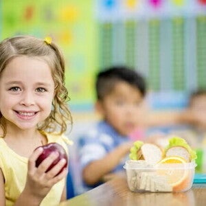 Prevenir la obesidad infantil Niña comiendo frutas en la escuela