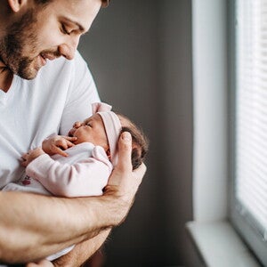 Los granitos en la cara de los bebés es un fenómeno común Papá alzando su bebé y revisando los granito de su cara