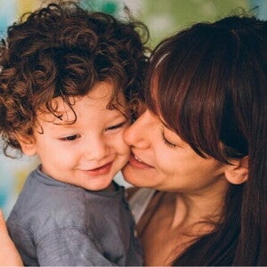 Leche en polvo: ¿Qué es y beneficios? Madre dando besos a su hijo