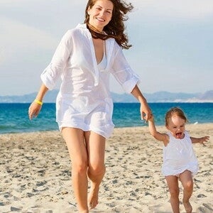 mamá bebé caminado felices Mamá con bebe caminando y jugando en la playa cuidan de su salud