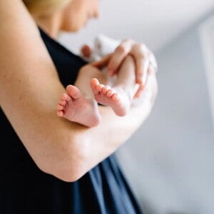 Mamá meciendo a bebé recién nacido.