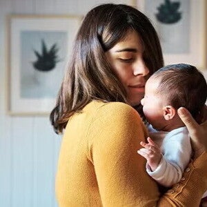 Mamá cargando a un bebé recién nacido.