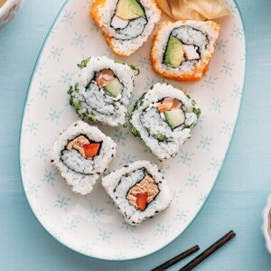 Sushi Bowl con Ensalada de Surimi y Batido Sushi en un bowl con palillos chinos a un lado