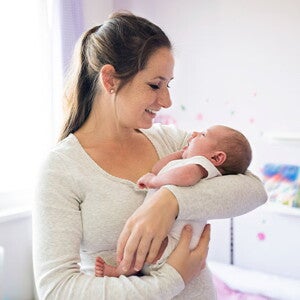 Conoce todo lo que debes saber si eres mamá primeriza. Mamá primeriza alzando en brazos a su bebé recién nacido.