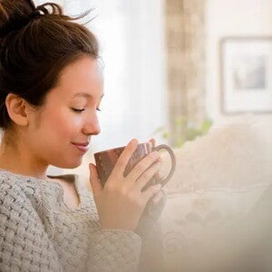 Mujer tranquila pensando y tomando café sobre vitaminas para embarazarse Mujer tranquila pensando y tomando café sobre vitaminas para embarazarse
