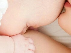 Close up de mamá dando pecho a su bebé.