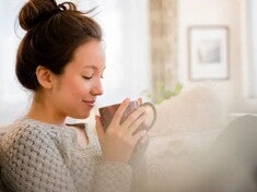 Mujer tranquila pensando y tomando café sobre vitaminas para embarazarse