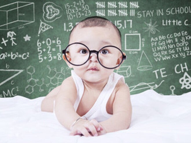 Bebé con gafas mirando la cámara con dibujos de fondo Bebé con gafas mirando la cámara con dibujos de fondo