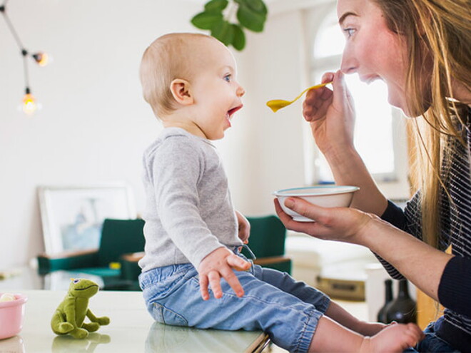 Conoce el desarrollo de tu bebé de 10 meses. Bebé de 10 meses sentado comiendo con mamá