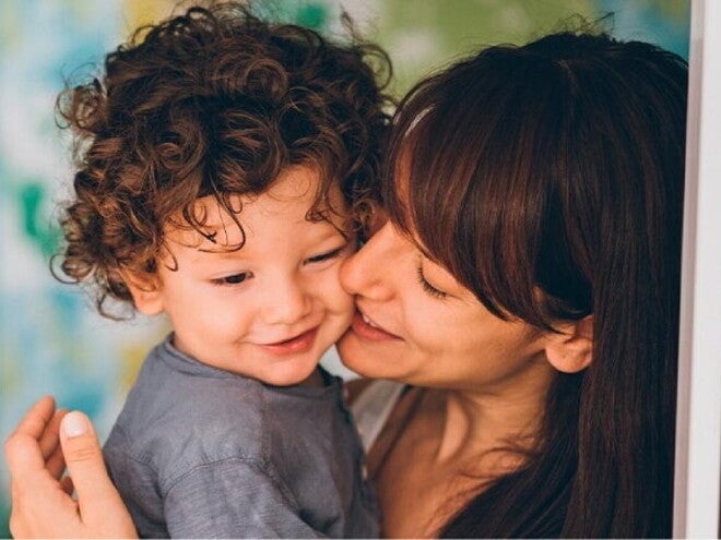Madre besando a su hijo en la mejilla
