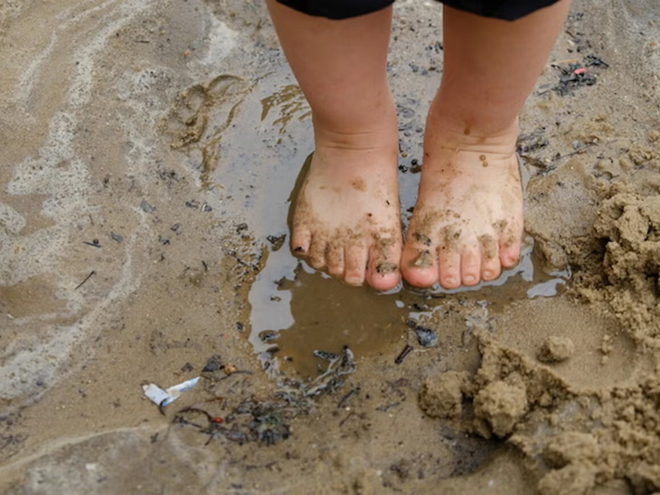 ¿Por qué debes dejar que tu hijo se ensucie? Pies de niño pequeño sobre agua con lodo aprende ensuciándose.