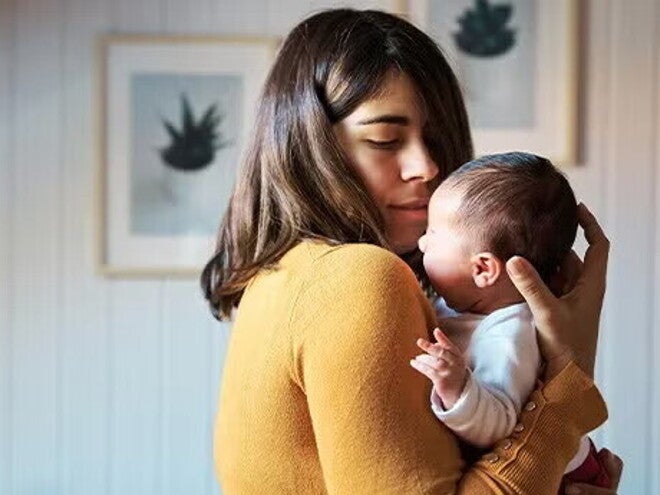 Mamá cargando a un bebé recién nacido.