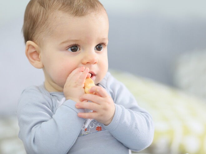 Bebé comiendo con las manos.