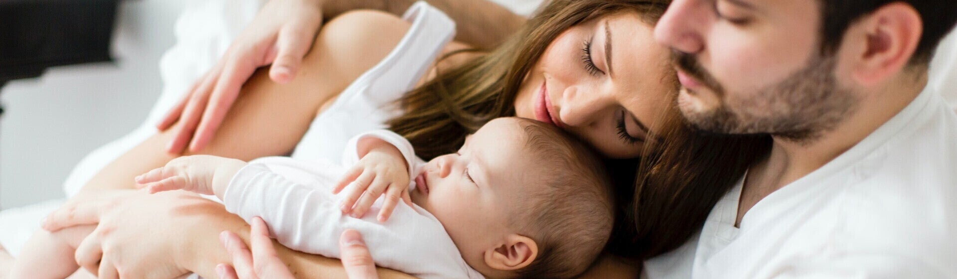 Mamá y papá acostados con su bebé Mamá y papá acostados con su bebé