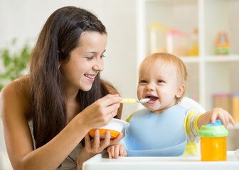 Mamá dándole comida a su bebé Mamá dándole comida a su bebé