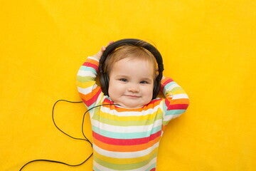 Un niño sonriendo a la camara con audifonos puestos Un niño sonriendo a la camara con audifonos puestos