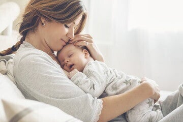 Una madre abrazando a su bebé mientras duerme en su pecho Una madre abrazando a su bebé mientras duerme en su pecho