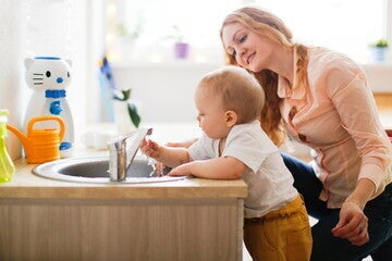Una madre y su bebé lavandose las manos Una madre y su bebé lavandose las manos