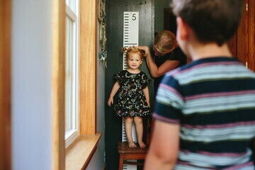 Una madre midiendo la estatura de su hija en la pared Una madre midiendo la estatura de su hija en la pared