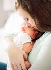 Una madre sosteniendo a su bebé Una madre sosteniendo a su bebé