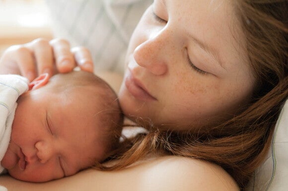 Vínculo afectivo y el Desarrollo Emocional Madre abrazando a su bebé en la cama