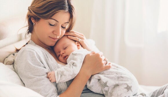 Mamá abrazando bebé y velando por su crecimiento Mamá abrazando bebé y velando por su crecimiento